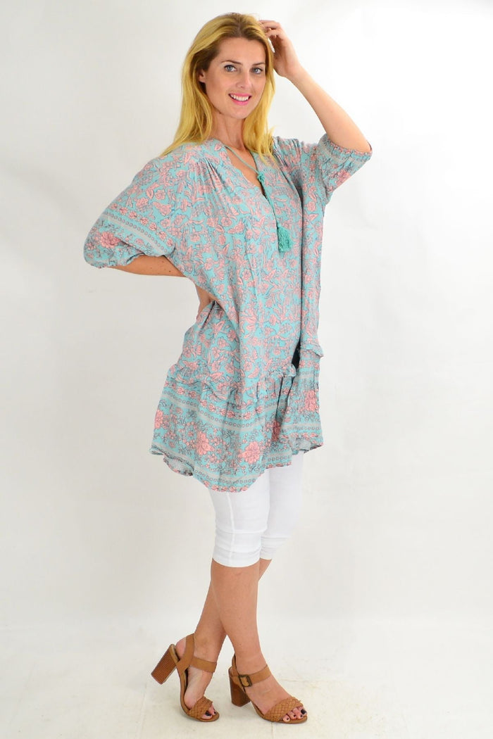 Aqua blue Style Fashion ruffle tunic top with flowy fabric and ruffled sleeves, displayed on a hanger.