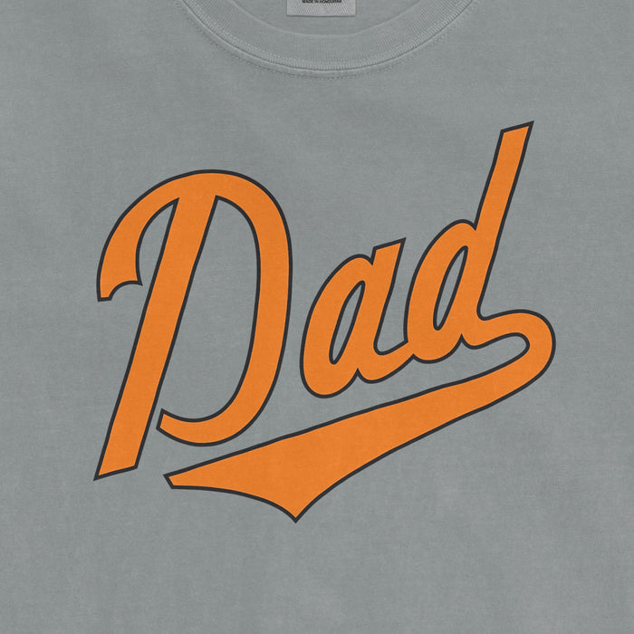 Comfort Colors tee featuring "Baltimore Baseball Dad" text in orange with black outline on a light gray fabric.