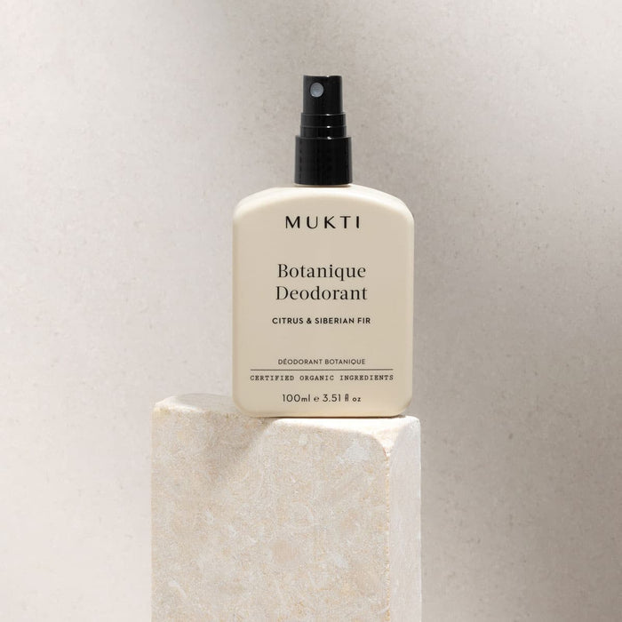 MUKTI Botanique Deodorant - Citrus & Siberian Fir 100ml spray bottle on a stone block.