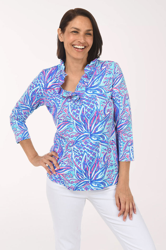 Woman wearing a colorful patterned blouse on a white background