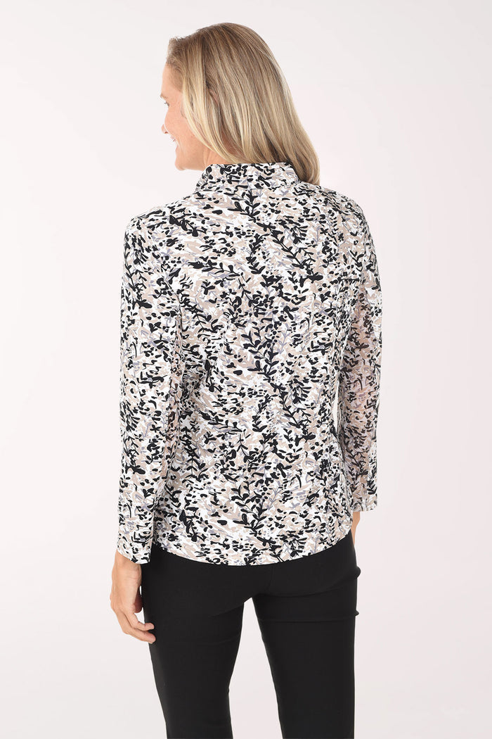 Woman wearing a black and white floral blouse on a white background