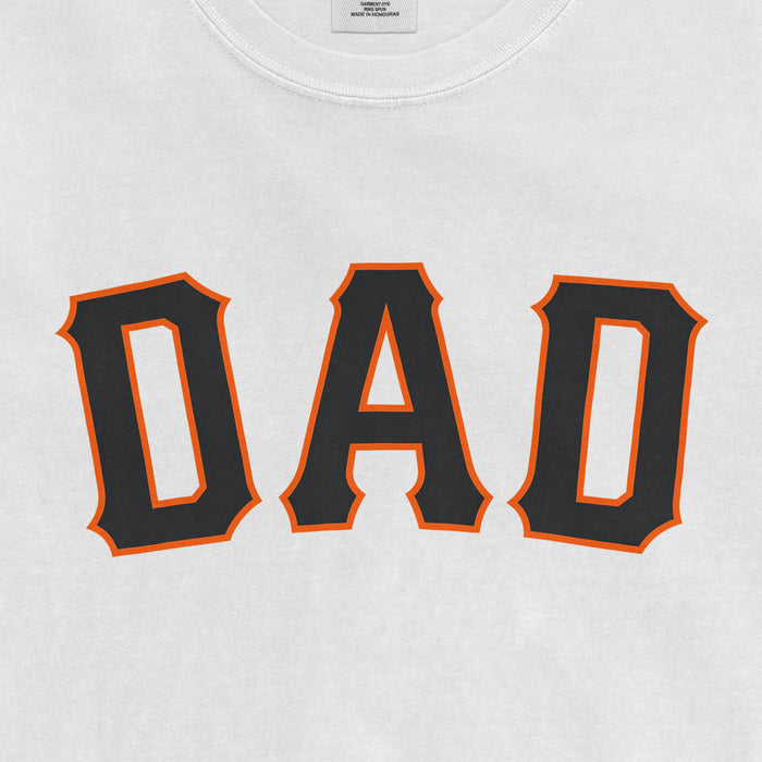 Close-up of a white T-shirt with "DAD" printed in bold black letters outlined in orange, celebrating San Francisco baseball dads.