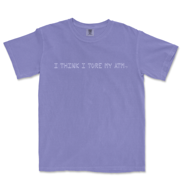 Lavender T-shirt with the phrase "I THINK I TORE MY ATM." embroidered across the front in white.