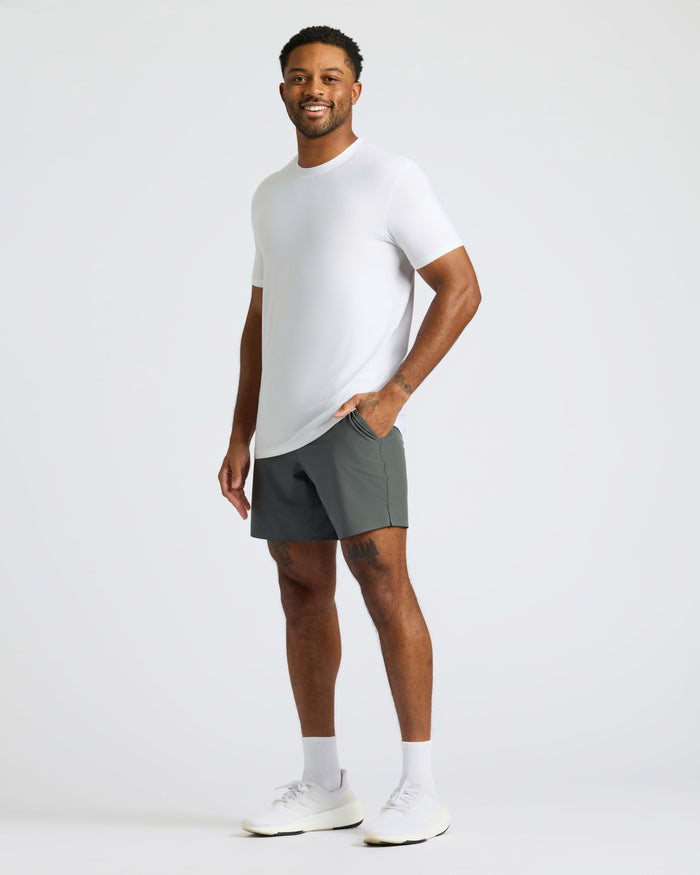 Man wearing White Active Crew Neck Tee, gray shorts, and white shoes.