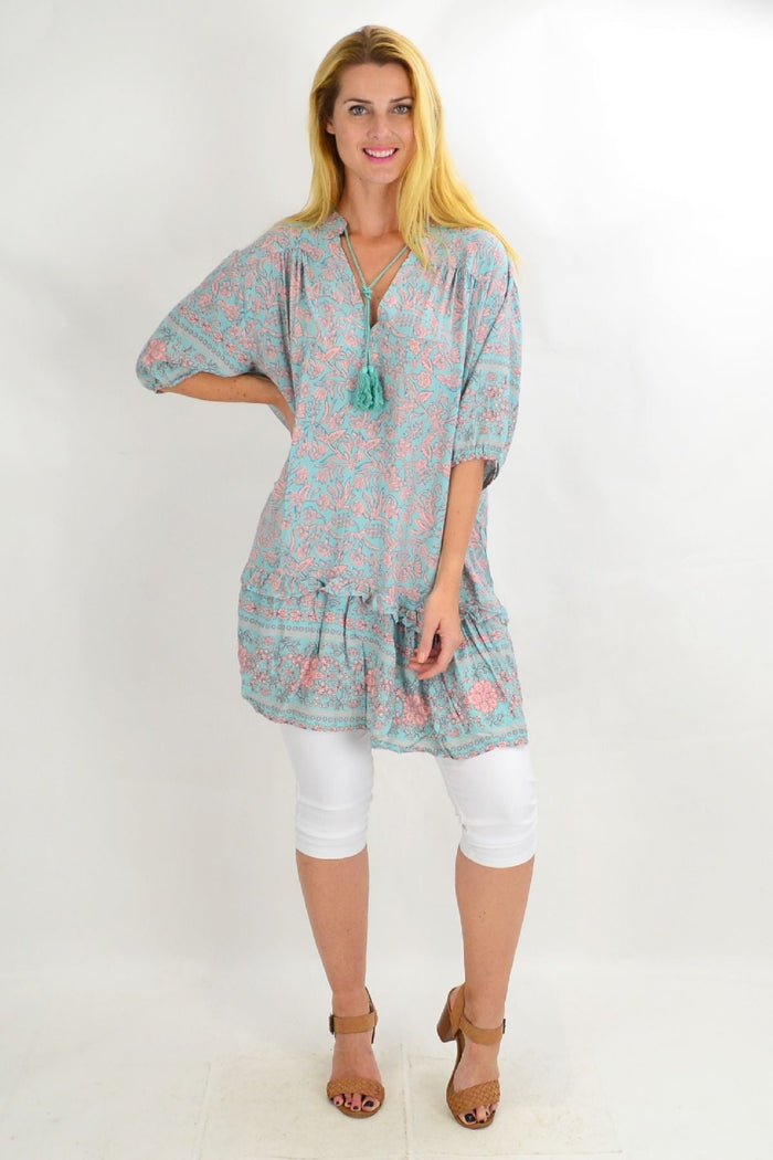 Aqua Bell Ruffle Tunic Top by Style Fashion, featuring ruffled sleeves and a flowy fit, displayed on a hanger with a neutral background.