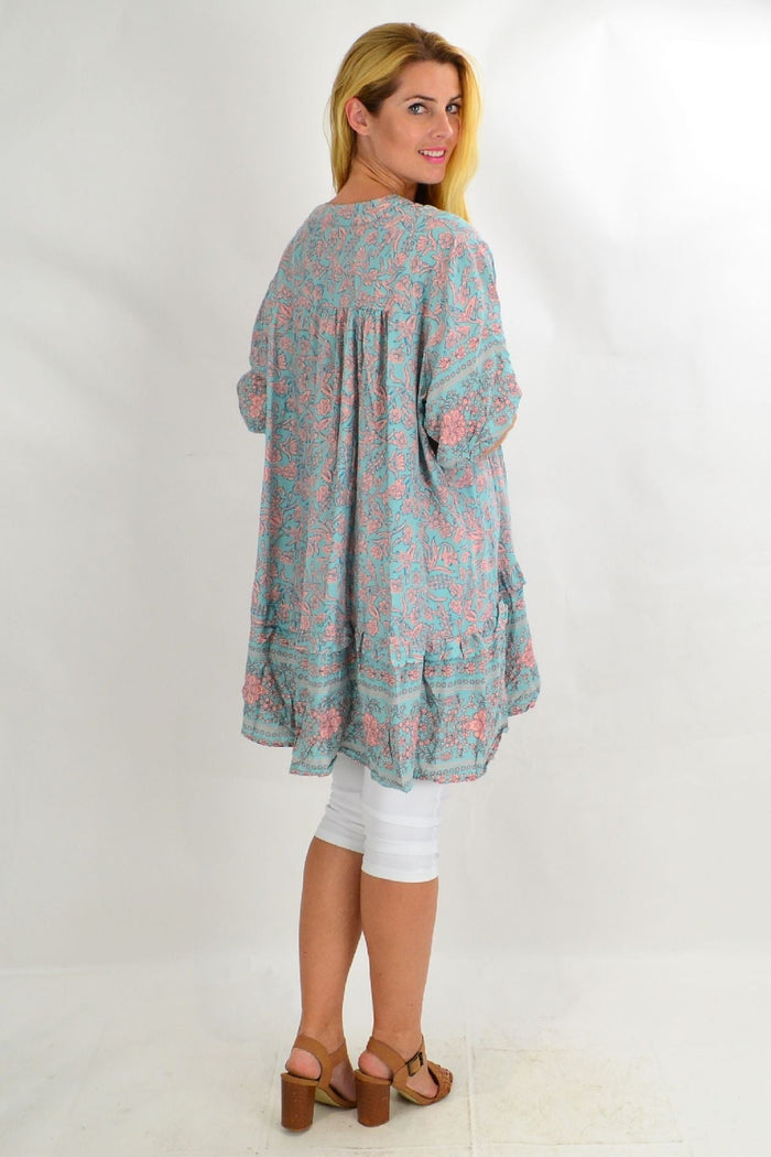 Aqua Bell Ruffle Tunic Top by Style Fashion, featuring flowy fabric, ruffle details, and a relaxed fit, displayed on a hanger.