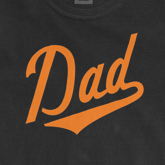 Black Comfort Colors tee with orange "Dad" text and swoosh design, celebrating Baltimore baseball dads.
