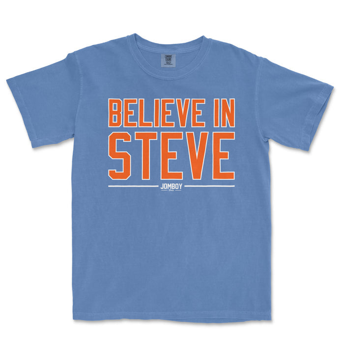 Blue Comfort Colors T-shirt with bold orange and white "Believe in Steve" text and a small Jomboy logo below.