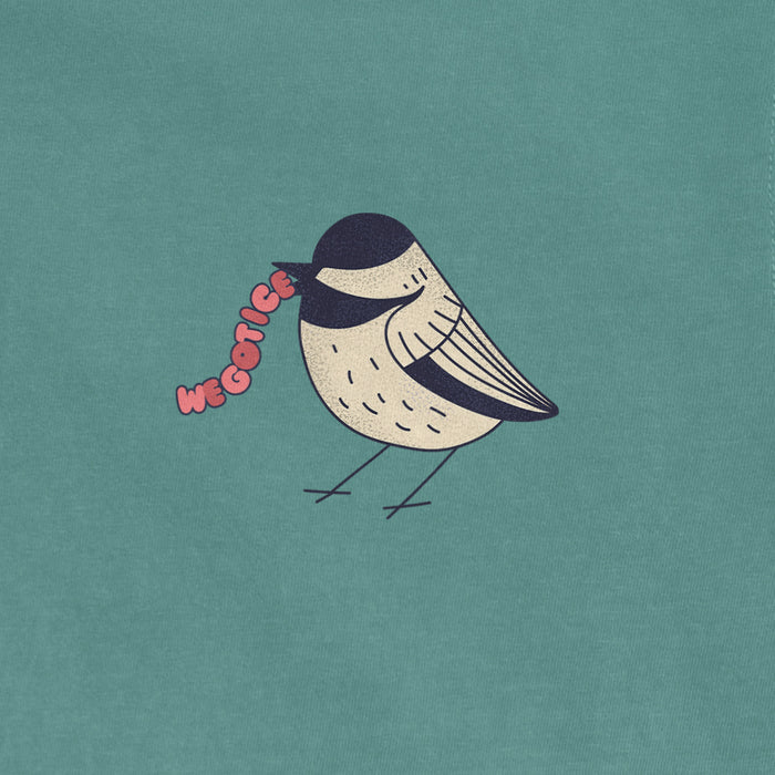 A vintage Comfort Colors® t-shirt features a cute bird illustration with the text "We Got Ice" in pink, set against a teal background.