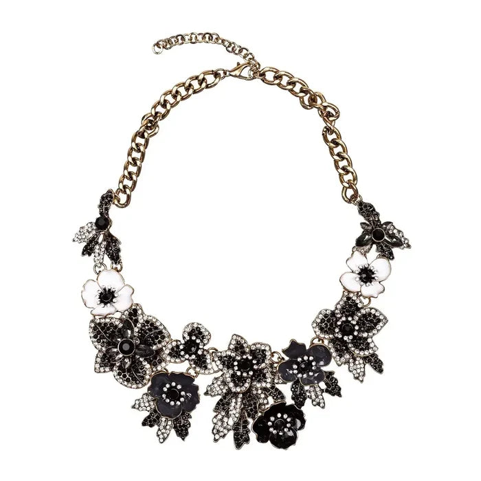 Black Amata statement necklace with black and white floral motifs, crystal embellishments, and an adjustable chain.