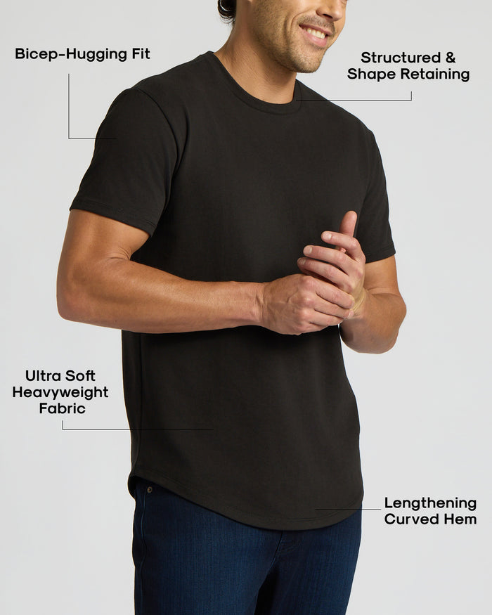 Man wearing a black Heavyweight Curved Hem Crew 6-Pack t-shirt with a bicep-hugging fit, structured shape retention, ultra-soft heavyweight fabric, and a lengthening curved hem.