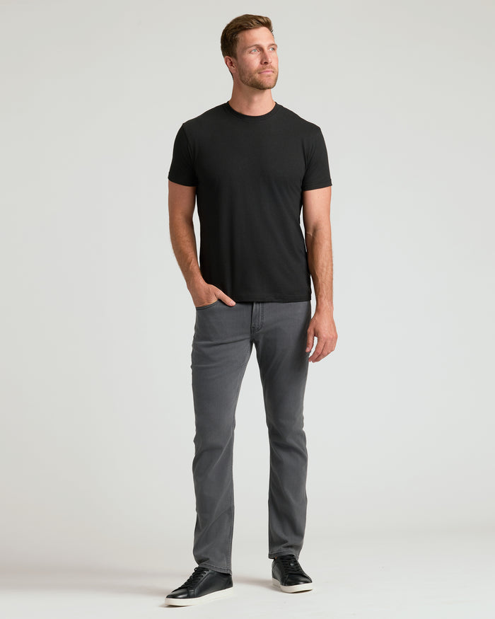 Man wearing Classic Crew 10-Pack: black T-shirt, gray jeans, sneakers.