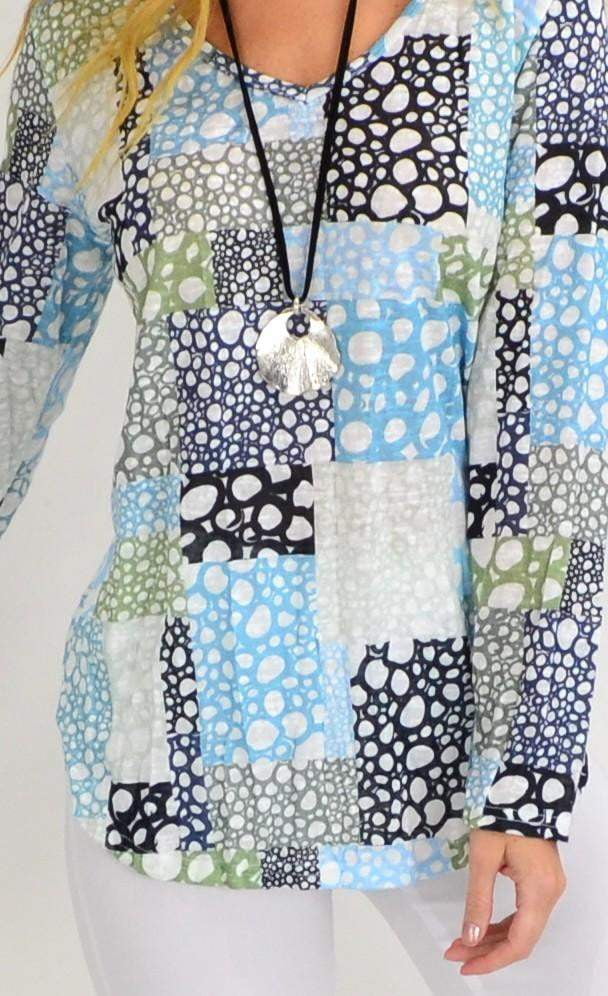 Cafe Latte Bubble Bath V-neck Tunic Top displayed on a hanger, showing its relaxed fit and soft fabric in a light, bubbly color.