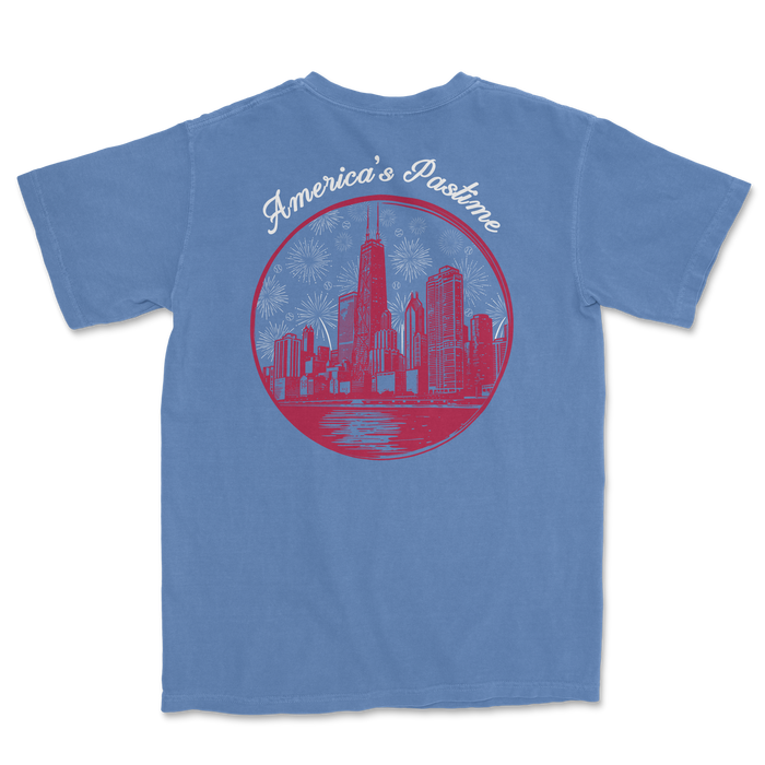 Blue t-shirt featuring a graphic of a city skyline with fireworks and the text "America's Pastime" in a circular design.