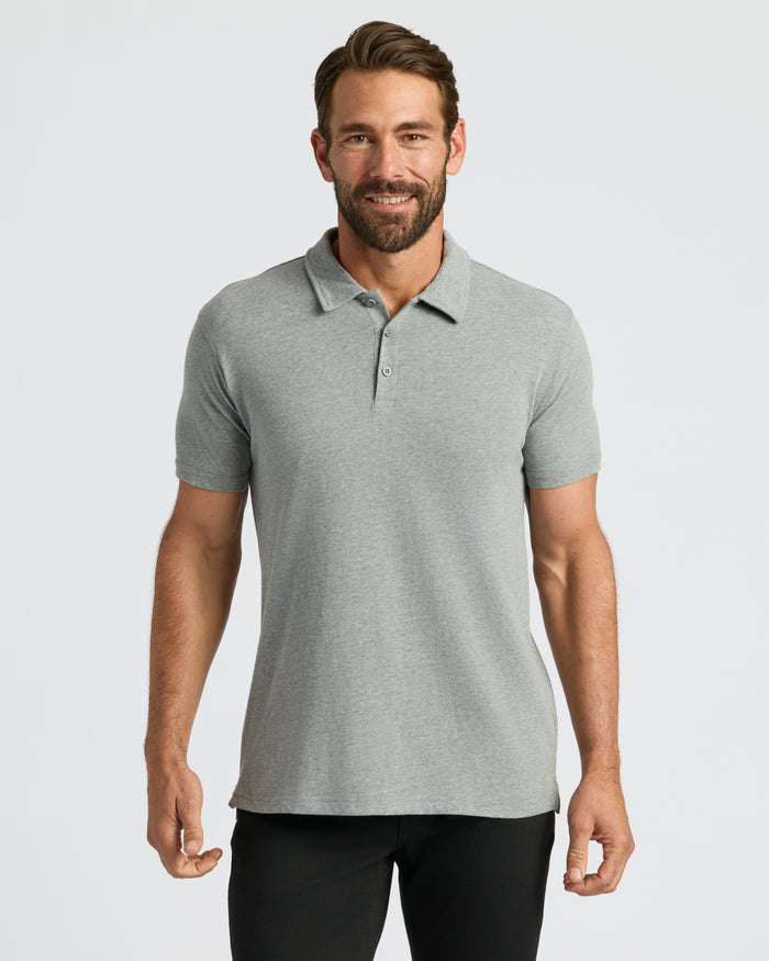 Man wearing Classic Polo, light-gray, short-sleeve, with dark trousers, smiling.