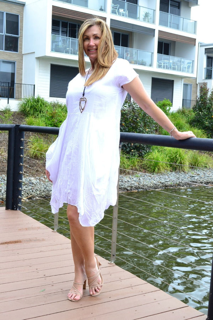 White cotton Sophia tunic dress by Wishstone, featuring a relaxed fit and simple neckline, displayed on a hanger.
