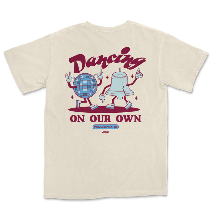 Comfort Colors tee featuring animated dancing disco ball and bell characters with "Dancing on Our Own" text and Philadelphia, PA label.