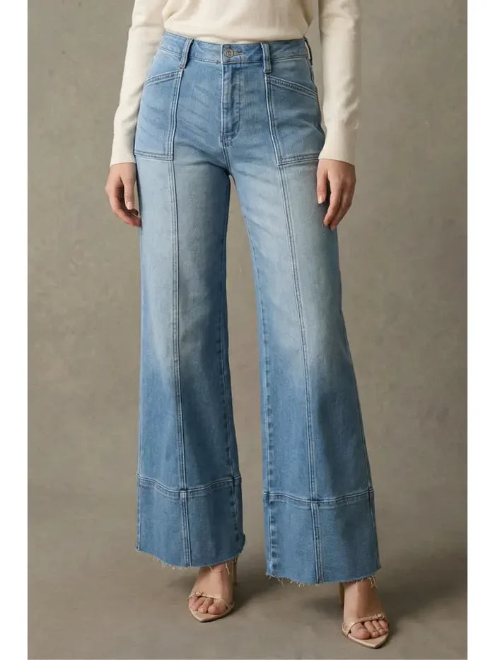 Light wash high rise palazzo jeans with visible front seams, a wide leg silhouette, and raw hem detail.