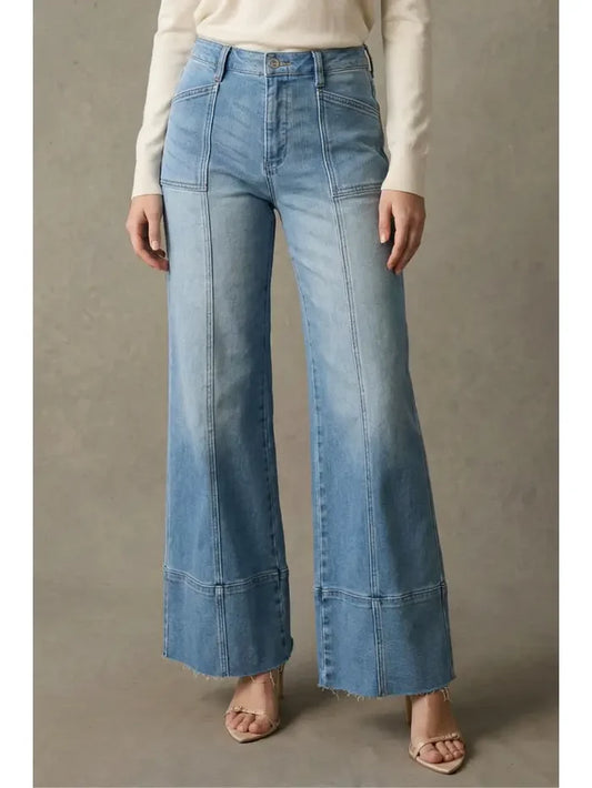 Light wash high rise palazzo jeans with visible front seams, a wide leg silhouette, and raw hem detail.
