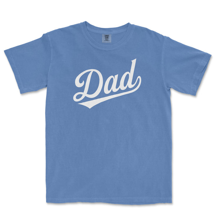 Blue Comfort Colors T-shirt with white "Dad" text in a cursive font, designed for baseball dads.