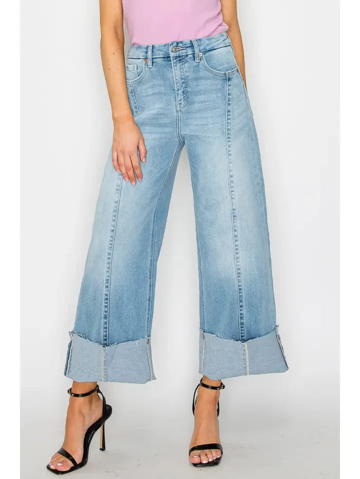 Light wash wide leg jeans with oversized turn-up cuff hems and a relaxed statement denim silhouette.