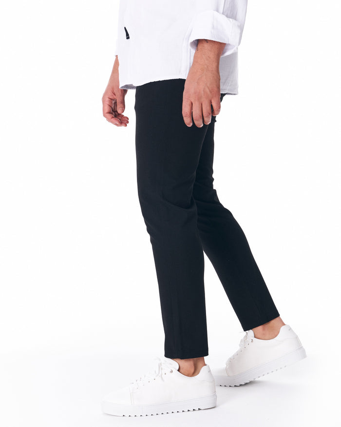 Martin Valen men's black trousers, mid-leg side view with hand in pocket and subtle side seam detail