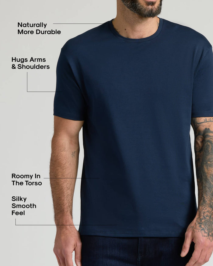 Man wearing a navy blue Pima Cotton Blend Crew 4-Pack t-shirt highlighting its natural durability, comfortable fit that hugs arms and shoulders, roomy torso, and silky smooth feel.