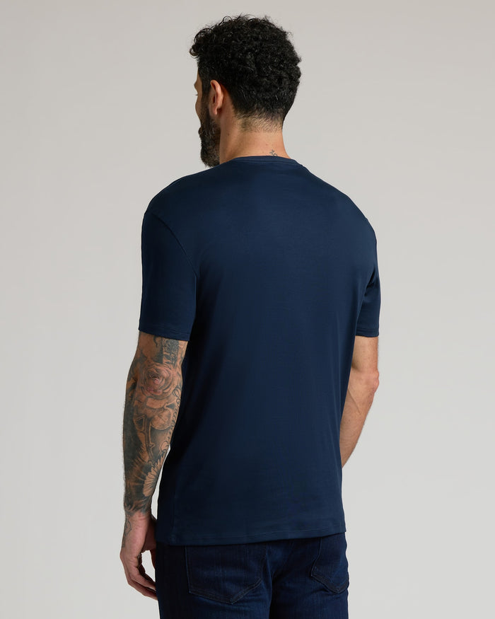 Man wearing a navy blue Pima Cotton Blend Crew 4-Pack short sleeve shirt, shown from the back, highlighting a comfortable fit and smooth fabric in a men's basics style.