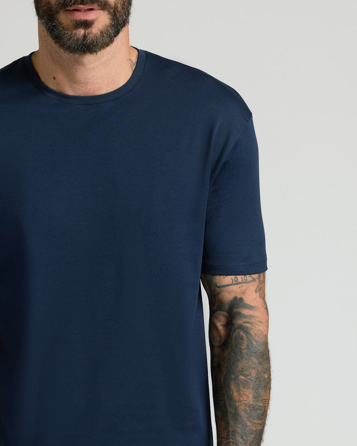 Close-up of a man wearing a Navy Pima Cotton Blend Crew shirt, featuring a soft texture and comfortable fit, showcasing casual men's basics style.