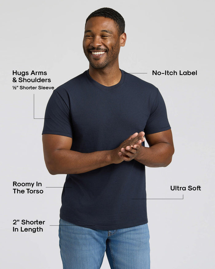 Man wearing a navy blue t-shirt with text highlighting features on a light gray background