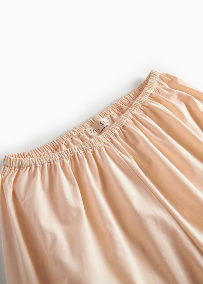 Beige pyjamasbukser med elastisk linning og orange piping ved benkanten