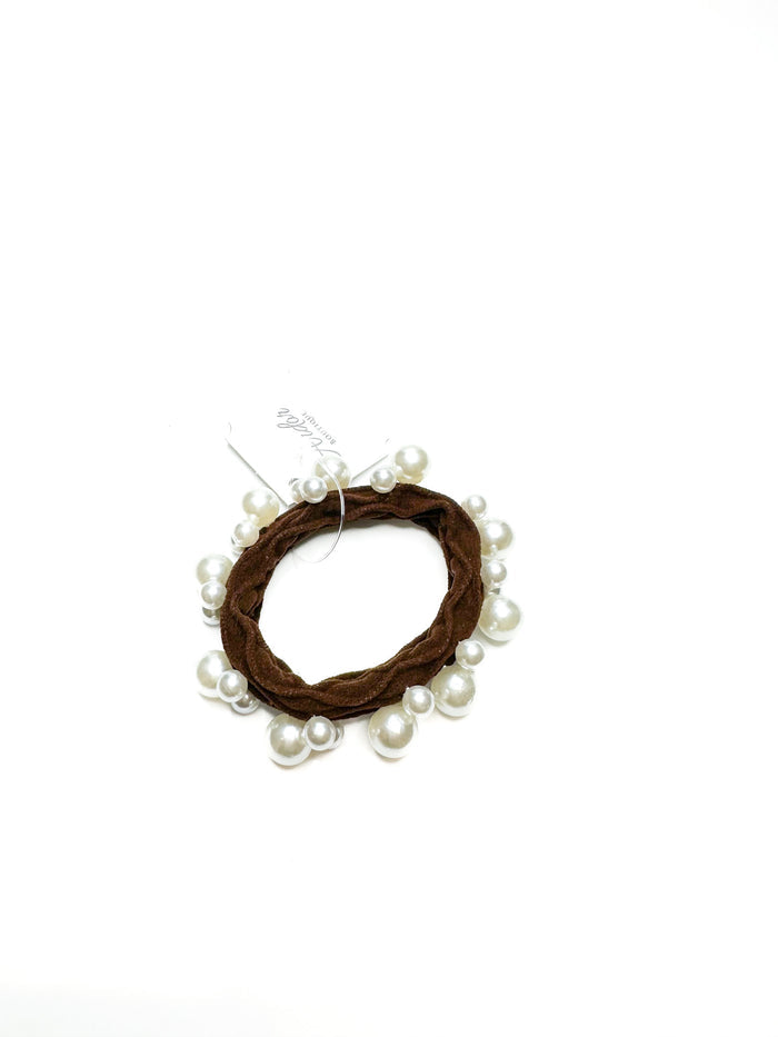 Hair tie with brown yarn and pearls on a white background