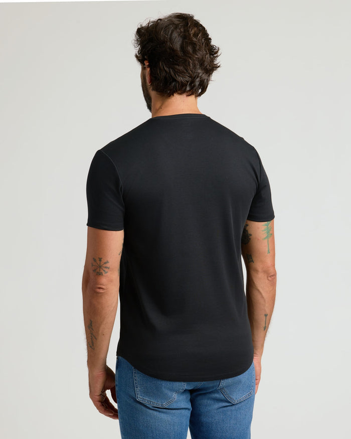 Man wearing a black Pima Cotton Blend Curved Hem Crew 7-Pack t-shirt shown from the back, paired with blue jeans, highlighting the curved hem design and comfortable fit.