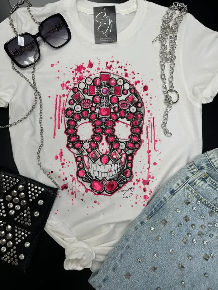 White short-sleeve crew-neck tee featuring a skull graphic with pink gem-inspired accents and artistic splatter details.