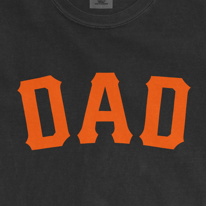 Close-up of a black T-shirt with bold orange text reading "DAD," celebrating San Francisco baseball dads.