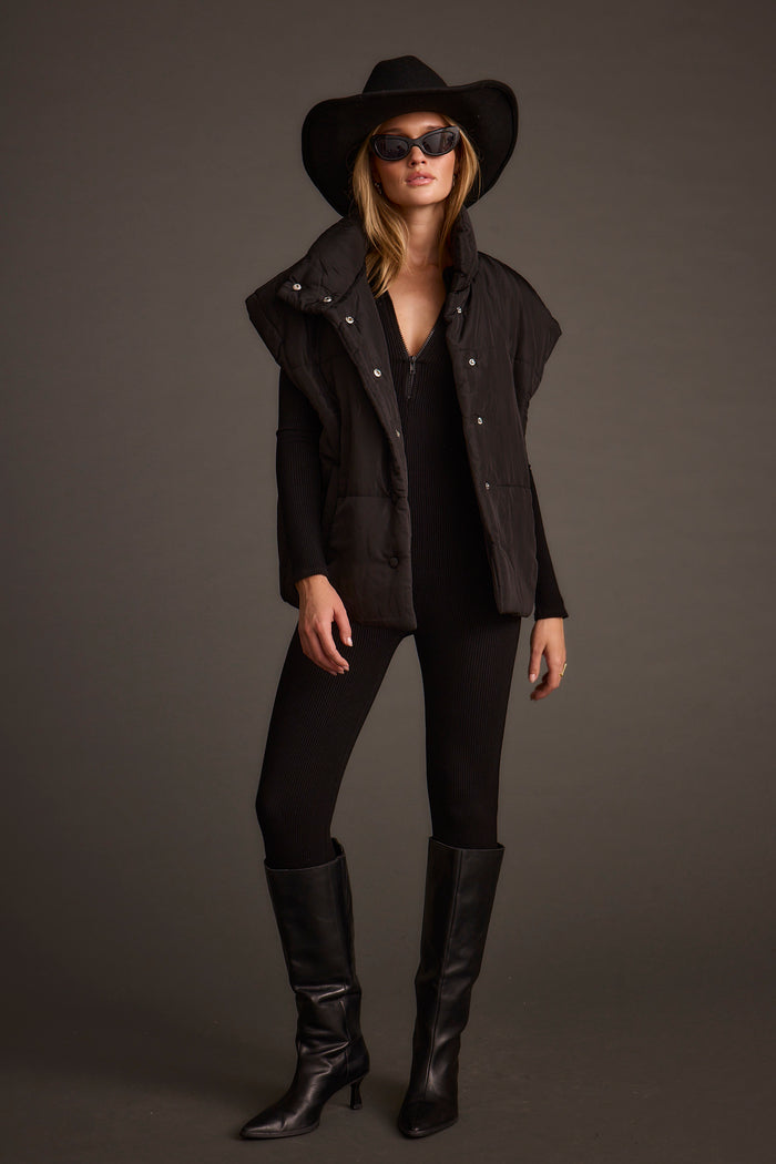 Full-length view of the black vest showing the drape and movement.