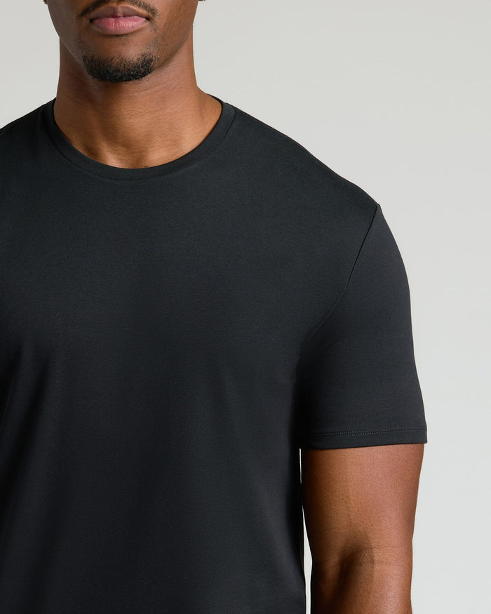 Close-up of a man wearing a black crew neck t-shirt made from a soft, breathable fabric, part of the Tall Pima Cotton Blend Crew 7-Pack men's basics collection.