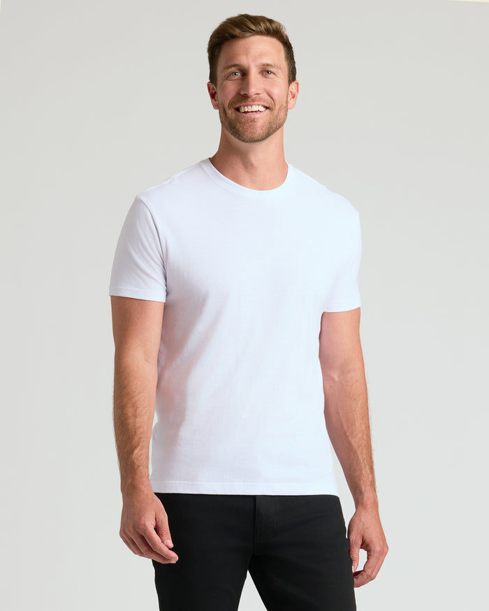 Man in white Staple Classic Crew Neck T-shirt, smiling, arms relaxed.