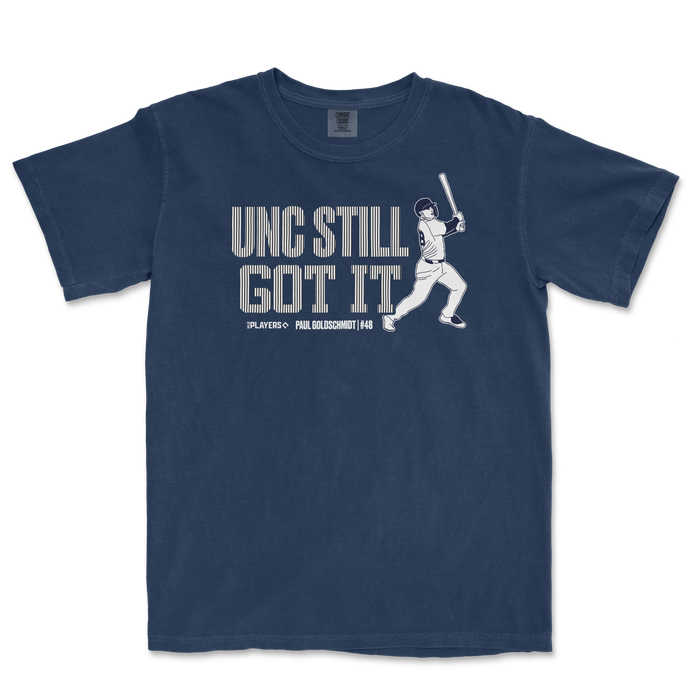 Navy blue t-shirt featuring the phrase "UNC Still Got It" and a graphic of a baseball player swinging a bat.