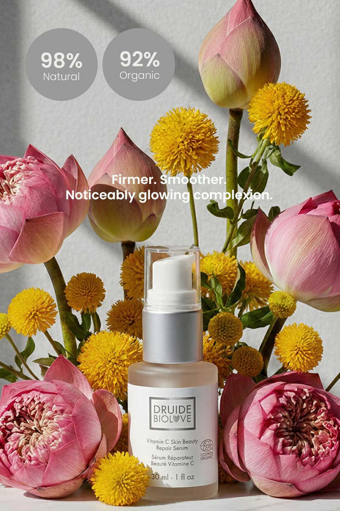 Druide Biolove Organic Vitamin C serum  surrounded by fresh Acmella Oleracea and young Lotus flowers with captions stating 98% natural and 92% organic, and firmer, smoother, noticeably glowing complexion.