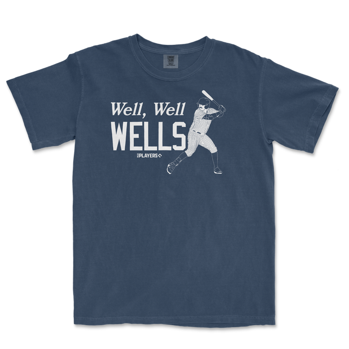 A blue T-shirt featuring a vintage baseball player illustration and the text "Well, Well WELLS" in bold white letters.