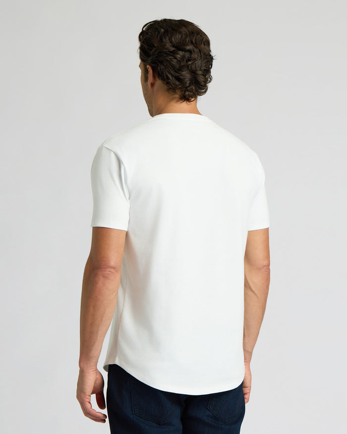 Man seen from behind wearing an All White Heavyweight Curved Hem Crew 3-Pack shirt, showcasing the curved hem and heavyweight fabric in a casual men's basics style.