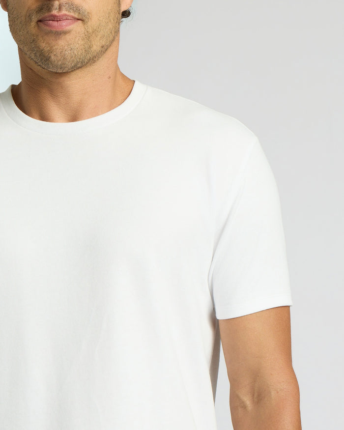 Close-up of a man wearing an All White Heavyweight Curved Hem Crew 3-Pack shirt, showcasing a clean, classic men's basics look with a smooth fabric and fitted short sleeves.