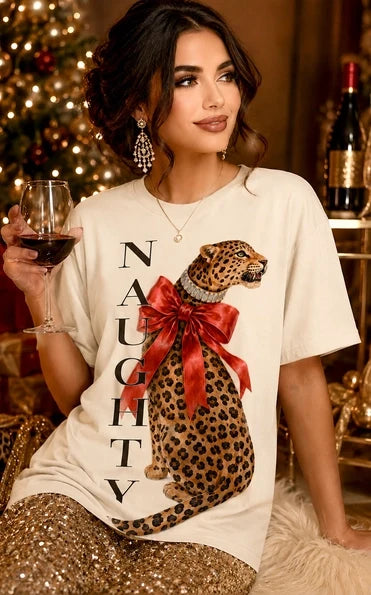 White short sleeve graphic tee featuring a bold leopard design with a red bow and Naughty lettering.