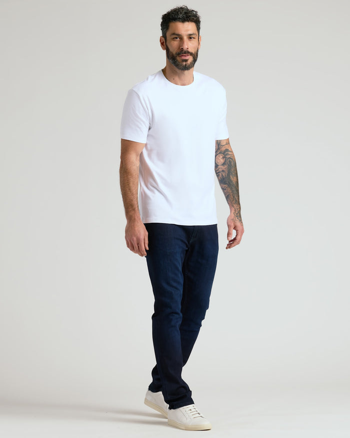 Man wearing a white crew neck t-shirt paired with dark jeans and white sneakers, showcasing the Black & White Pima Cotton Blend Crew 7-Pack in a casual, modern style.