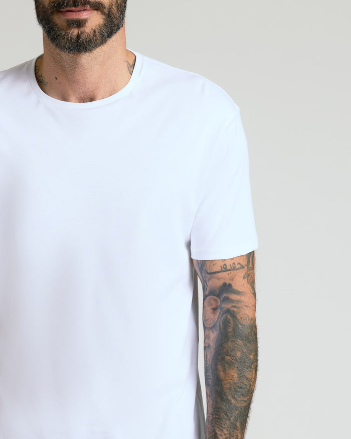 Man wearing a plain white crew neck t-shirt from the Pima Cotton Blend Crew 4-Pack, featuring short sleeves and a comfortable fit, showcasing a tattooed arm.