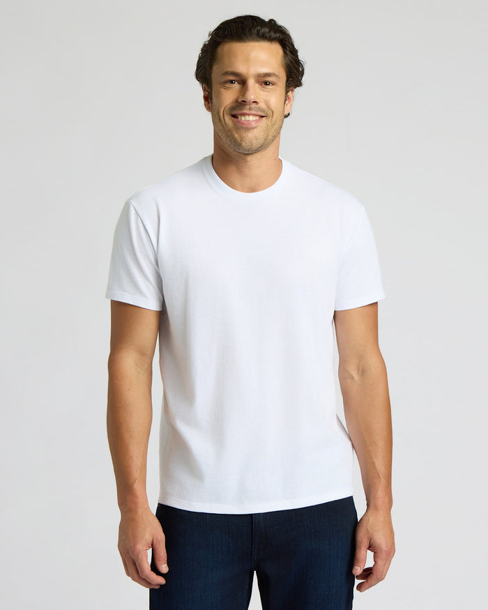 Man wearing a plain white t-shirt against a light gray background