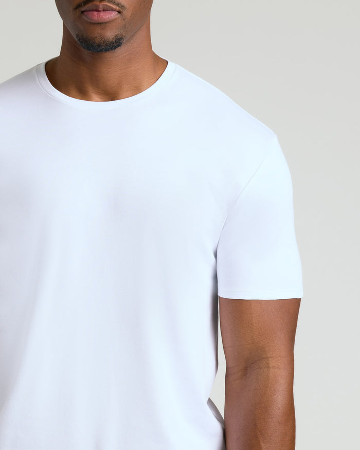 Close-up of a man wearing a plain white crew neck t-shirt, showcasing the fit and texture of the Tall Pima Cotton Blend Crew 4-Pack men's basics.